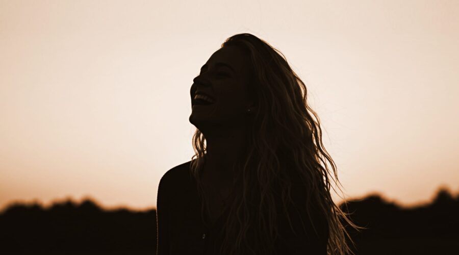 woman laughing to raise her vibration